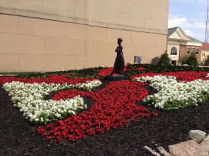 The flowers have filled in the Drunkard's Path quilt, across from the Midwest Museum of American Art.  It now looks spectacular.  That's Tuck's sculpture, Matriarch, in the center.